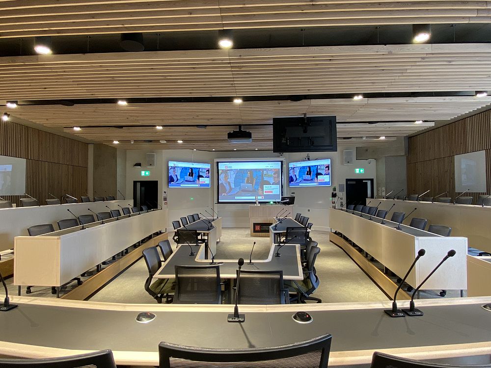 Conference room at LSE with microphones, large screens, and U-shaped seating.