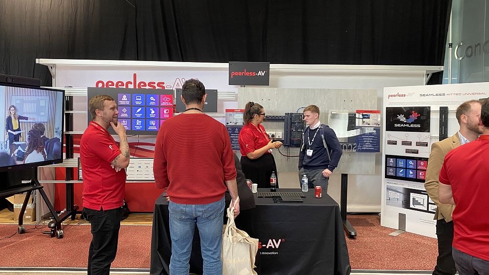 Peerless-AV representatives engaging with attendees and showcasing their products.